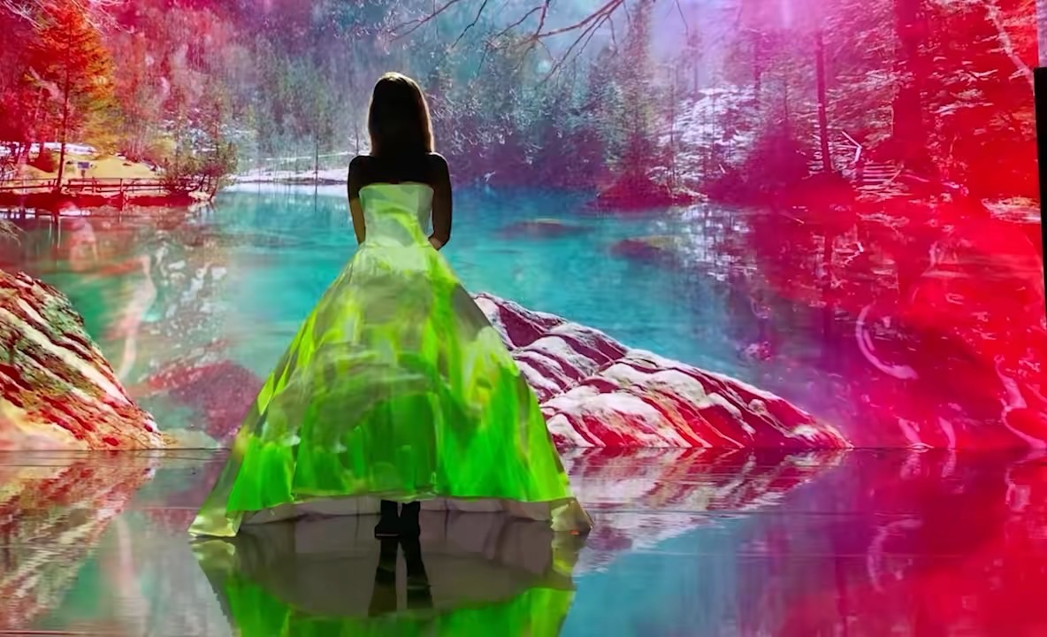 Custom content projection-mapped onto a runway gown: a stylized forest and river wrapping the dress